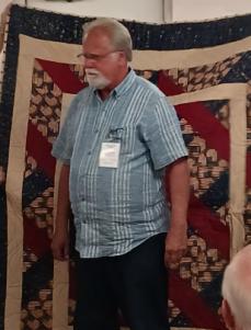 A person standing in front of a quiltAI-generated content may be incorrect.